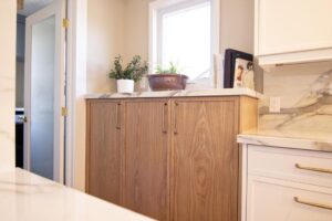 Custom storage cabinetry in natural wood between kitchen and laundry room.